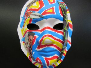 Unmasking Brain Injury mask painted with red, yellow and blue lines and designs