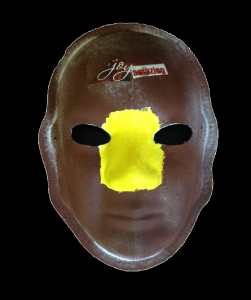 Unmasking Brain Injury mask painted brown with yellow between the eyes and on the nose