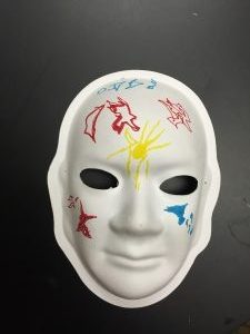 Unmasking Brain Injury mask painted with red, yellow and blue designs