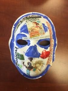 Unmasking Brain Injury mask painted blue and red with images and text