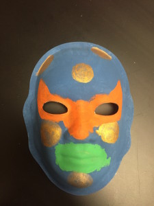 Unmasking Brain Injury mask painted blue, orange, green and gold