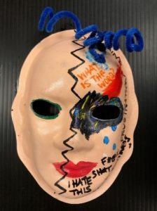Unmasking Brain Injury mask painted peach with text and zig zag lines