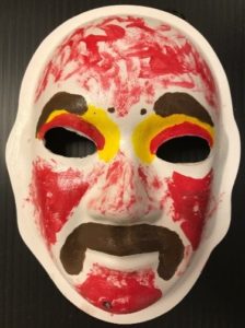 Unmasking Brain Injury mask painted red with facial features