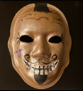Unmasking Brain Injury mask painted bronze with facial features
