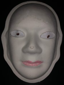 Unmasking Brain Injury mask painted with facial features