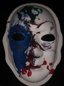 Unmasking Brain Injury mask painted with black, blue and red