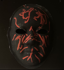 Unmasking Brain Injury mask painted black with red lines
