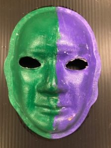 Unmasking Brain Injury mask painted half purple and half green