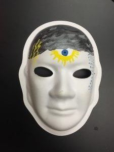 Unmasking Brain Injury mask painted with black on the head a nd a sun