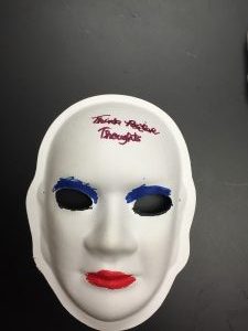 Unmasking Brain Injury mask painted with facial features and text on the forehead