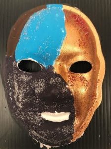 Unmasking Brain Injury mask painted gold, black and blue