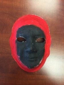 Unmasking Brain Injury mask painted black with red around the outside