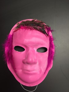 Unmasking Brain Injury mask painted pink with a feather