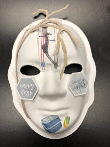 Unmasking Brain Injury mask with "happy days" on the left and "simply perfect" on the right