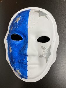 Unmasking Brain Injury mask painted white and blue with silver stars