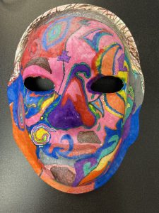 Unmasking Brain Injury mask with multicolored, swirly sections