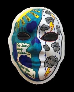 Unmasking Brain Injury mask painted half blue half white with thunderclouds painted on the right and text painted on the left