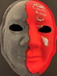Unmasking Brain Injury mask painted half black and half red