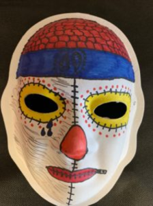 Unmasking Brain Injury mask painted with red and blue on the forehead and yellow around the eyes