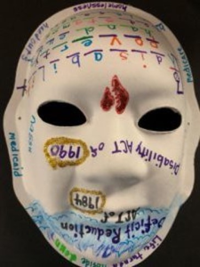 Unmasking Brain Injury mask painted with a lot of upside down text