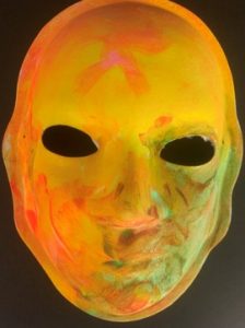 Unmasking Brain Injury mask painted with yellow, orange and green
