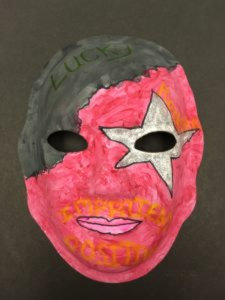 Unmasking Brain Injury mask painted with black and red with a silver star over one eye