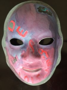 Unmasking Brain Injury mask painted with purple, pink and blue sections
