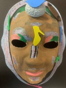 Unmasking Brain Injury mask painted yellow with silver sections
