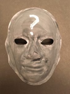 Unmasking Brain Injury mask painted gray with a white question mark