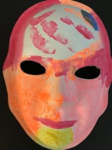 Unmasking Brain Injury mask painted with orange, yellow and pink