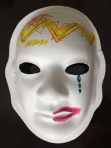Unmasking Brain Injury mask painted with multicolored lines on the forehead and tears