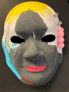 Unmasking Brain Injury mask painted with gray, white, blue, red and yellow