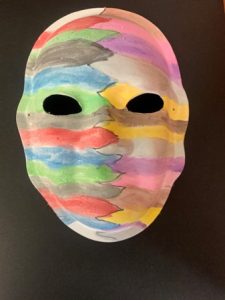 Unmasking Brain Injury mask painted with multicolored stripes