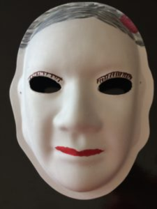 Unmasking Brain Injury mask painted with a hair, eyelashes and lips