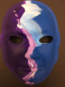 Unmasking Brain Injury mask painted with purple and blue with a light purple zig zag
