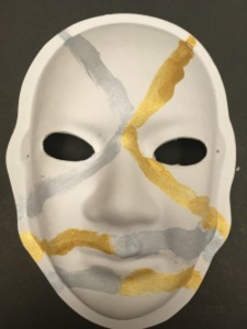 Unmasking Brain Injury mask painted with gold and silver lines