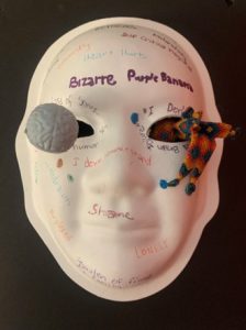 Unmasking Brain Injury mask painted white with text