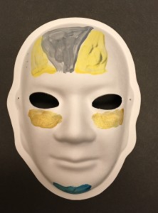 Unmasking Brain Injury mask painted with yellow, gray and blue sections