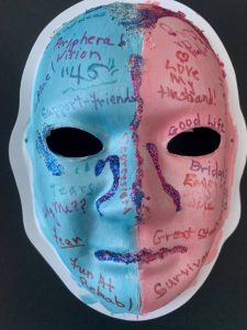 Unmasking Brain Injury mask painted blue and red with text written on top