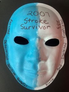 Unmasking Brain Injury mask painted blue and white with the words "2007 Stroke Survivor"