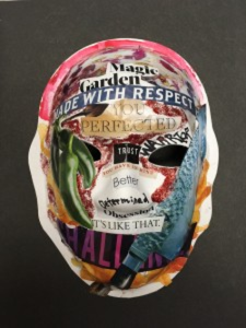 Unmasking Brain Injury mask with cutout magazine text collaged on it